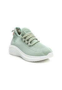 Zapatilla deportiva verde claro con una parte superior de malla transpirable, suela flexible y detalles texturizados. Presenta cordones elásticos y un collar acolchado.