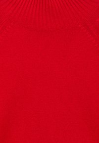 Roter Strickrollkragenpullover mit geripptem Kragen und sichtbaren Schulterdetails.