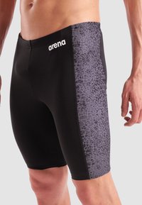 Schwarze Schwimmshorts mit einem strukturierten grauen Seitenpanel im Steinmuster. Hergestellt aus dehnbarem Material für Komfort und Leistungsfähigkeit.
