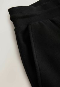 Sorte atletikbukser med en glat tekstur, med elastisk linning og sidelommer for bekvemmelighed. Enkel, funktionel design.