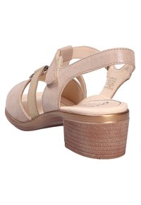 Beige Wildleder-Sandalette mit Absatz und verstellbarem Riemen, offener Rückseite und strukturiertem Plateau-Absatz. Verfügt über elastische Bänder für einen sicheren Halt.