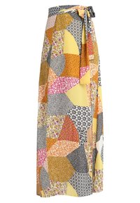 Gonna lunga in patchwork che presenta una varietà di motivi floreali e geometrici in giallo, rosa, nero e bianco, con un dettaglio di vita annodata.
