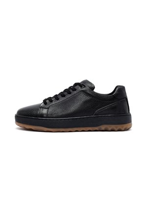Sneaker in pelle nera low-top con lacci neri e suola spessa nera con fondo marrone chiaro strutturato.
