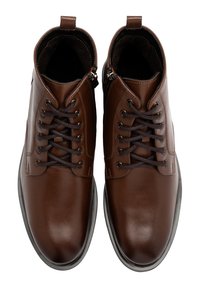 Brązowe skórzane buty o gładkim wykończeniu, z zapięciem na sznurówki, wysokości kostki i ciemno brązowymi akcentami. Zawierają detal w postaci bocznego zamka.