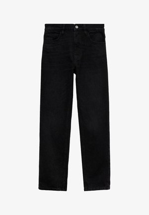 Kobieta w jasnoniebieskiej koszuli na guziki, czarnych spodniach z wysokim stanem, czarnych mokasynach, trzymająca małą czarną torebkę na jednym ramieniu.