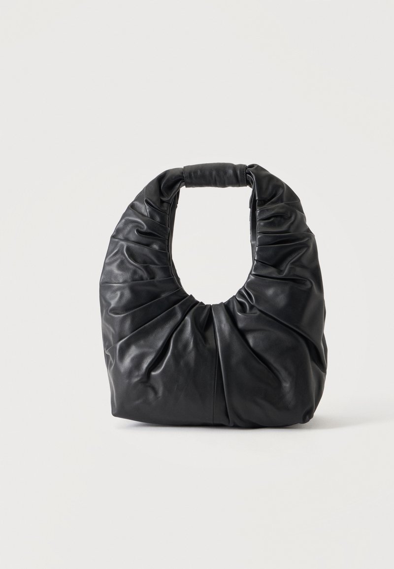 Sac à épaule en cuir souple noir avec des plis froncés et une poignée arrondie, debout sur un fond clair uni.