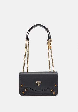 Sac d'épaule rectangulaire noir avec des bandoulières chaîne dorées, des clous dorés et un logo triangulaire Guess sur le rabat avant.