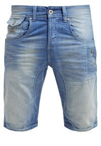 Farkkushortsit vaaleansinisessä sävyssä, jossa on haalistunut viimeistely. Ominaisuuksiin kuuluu nappisulku, taskut ja tikkaus yksityiskohtia edessä ja sivuilla.