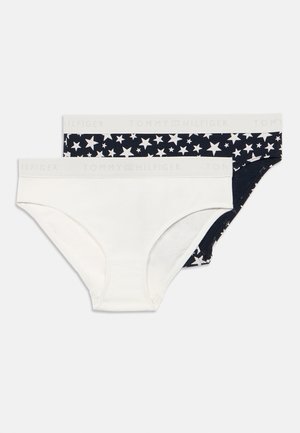 Dwa zestawy damskich majtek: jeden biały, drugi ciemnoniebieski w biały wzór gwiazdek, oba z elastycznymi pasami w talii z logo "TOMMY HILFIGER".