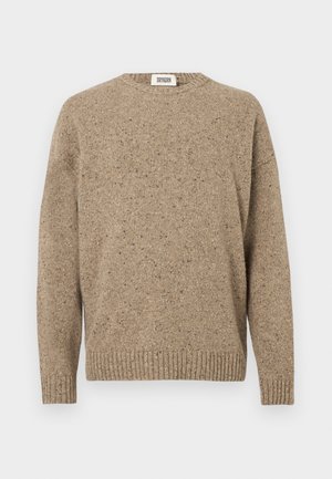 Beige strikket genser med rund hals, lange ermer og ribbestrikket kant. Den teksturerte stoffet har flekker av mørkere nyanser.