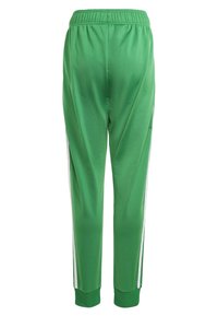 Gröna träningsbyxor med en slät textur, elastisk midja och vita sidostråk. Avsmalnande bendesign med ribbade mudd vid anklarna.