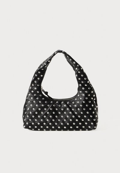 Bolso de mano de cuero negro con un asa curva, que presenta un patrón de tachuelas metálicas distribuidas uniformemente por toda la superficie. Cierre de cremallera.