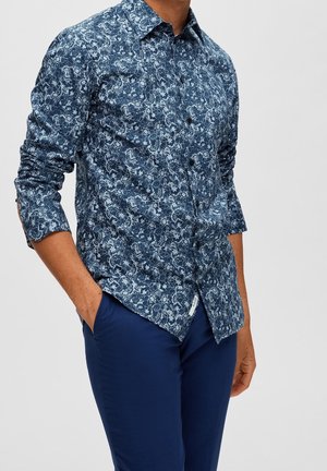 Hemd in marineblau mit Knöpfen und Paisleymuster, aus leichtem Stoff gefertigt. Lange Ärmel mit Knopfmanschetten, leicht abgerundeter Saum.