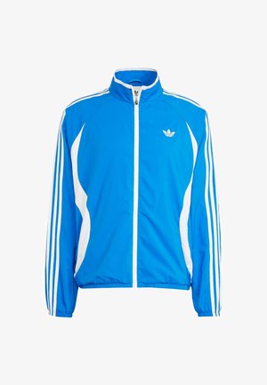 Chaqueta deportiva azul hecha de tejido suave, con acentos blancos, cuello alto, cremallera completa y tres rayas blancas en cada brazo.