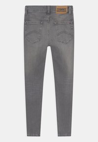 Harmaa farkku skinny-farkut, joissa on nahkainen logopatch vyötäröllä, kaksi takataskua ja ommeltuja yksityiskohtia. Sileä pinta ja istuva muotoilu.