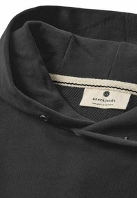 Schwarzer Hoodie mit einer glatten Textur und einem gemusterten Innenfutter. Verfügt über ein cremefarbenes Etikett mit Logo und Akzentnähten am Kragen.