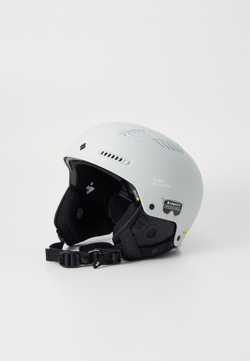 Gray ski helmet with ventilation slots, padded interior, adjustable straps, and logo details. Smooth texture with a matte finish.