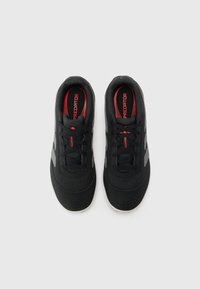 Black sports shoes with a mesh upper, grey accents, red branding, and perforated detailing on the toe. Features traditional lacing.