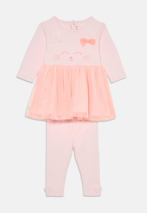 Rausvas dviejų dalių kostiumėlis, kuriame ilgarankovė palaidinė su katės veido motyvu, tinklelio sijonas ir derančios legginsai su širdelėmis ant rankogalių.