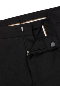 Black pants featuring a zippered fly, a snap button closure, and a smooth texture with subtle stitching details. Interior includes contrasting stripes.