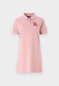 Rosa polo-shirt med krage, utrustad med en broderad "LA"-logotyp i mörkröd och ett blommönster. Tillverkad av mjukt, lätt tyg.