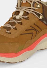 Chaussure de randonnée imperméable marron et beige avec des lacets beige à motifs, un accent corail sur la semelle intermédiaire et une semelle extérieure blanc cassé texturée.