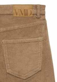 Corduroy pantalons in een gedempt tan kleur, met een rechthoekig leren label met "VMD," en een achterzak met een gestikte rand.