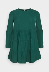 Vestito verde a maniche lunghe con scollatura tonda, design a più strati e tessuto morbido. Presenta una chiusura a oblò sul retro e una silhouette fluida.