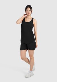 Camiseta sin mangas atlética negra y pantalones cortos, hechos de tela liviana. La parte superior tiene un escote redondo y los pantalones cortos cuentan con bolsillos laterales.