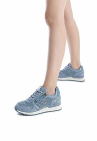 Zapatillas deportivas de color azul claro con un diseño de malla tejido, acentos de ante suave, cierre con cordones y un detalle de cremallera en el lateral.