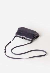 Borsa a tracolla in pelle viola con una forma morbida e arrotondata, dotata di chiusura a gancio, lunga tracolla e sottili dettagli di cucitura a contrasto.