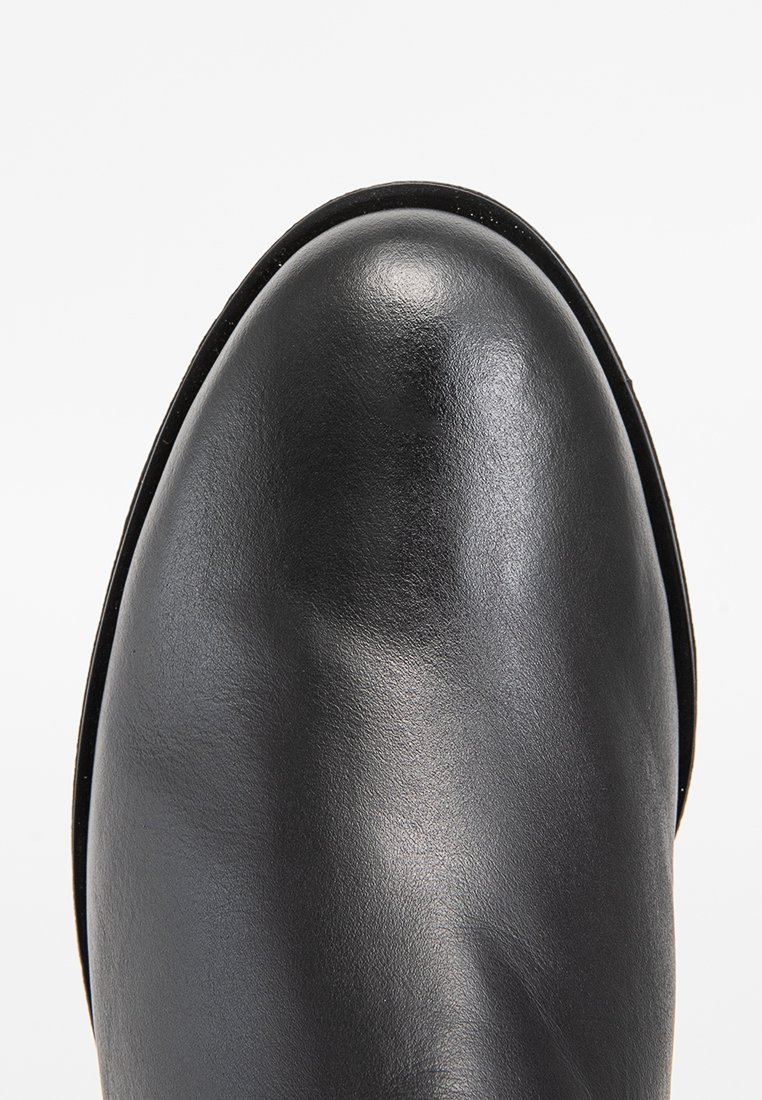 Schwarze Lederstiefelette mit abgerundeter Zehenpartie, glatter Oberfläche und minimalem Nähdetails. Die Sohle ist leicht erhöht und sorgt für einen auffälligen Look.