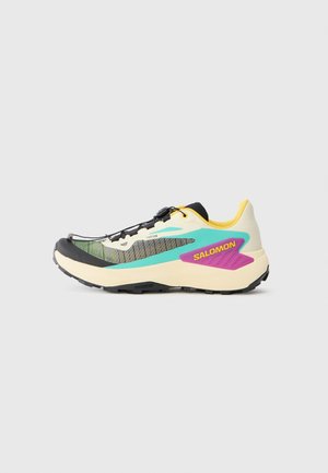 Chaussure de course avec une tige en mesh léger de couleur blanche, verte et noire, avec une accent jaune et un logo violet. Design élégant et durable.