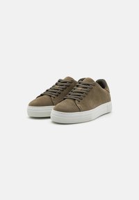 Olivengrønn semsket skinn sneakers med rund form, hvite gummisåler og matchende olivenfargede snører, med minimalistiske designdetaljer.