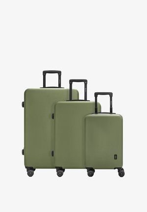 Tres maletas rígidas de color verde oliva en tamaños pequeño, mediano y grande, con asas retráctiles negras y cuatro ruedas giratorias.