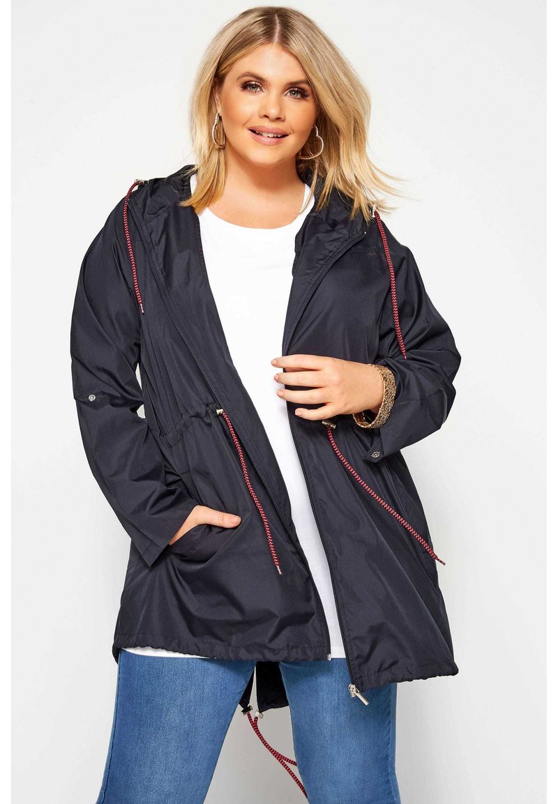 Sini takki, jossa on kiristettävä huppu, etutaskut ja rento malli. Valmistettu kevyestä materiaalista, jossa on sileä pinta ja punaiset yksityiskohdat.