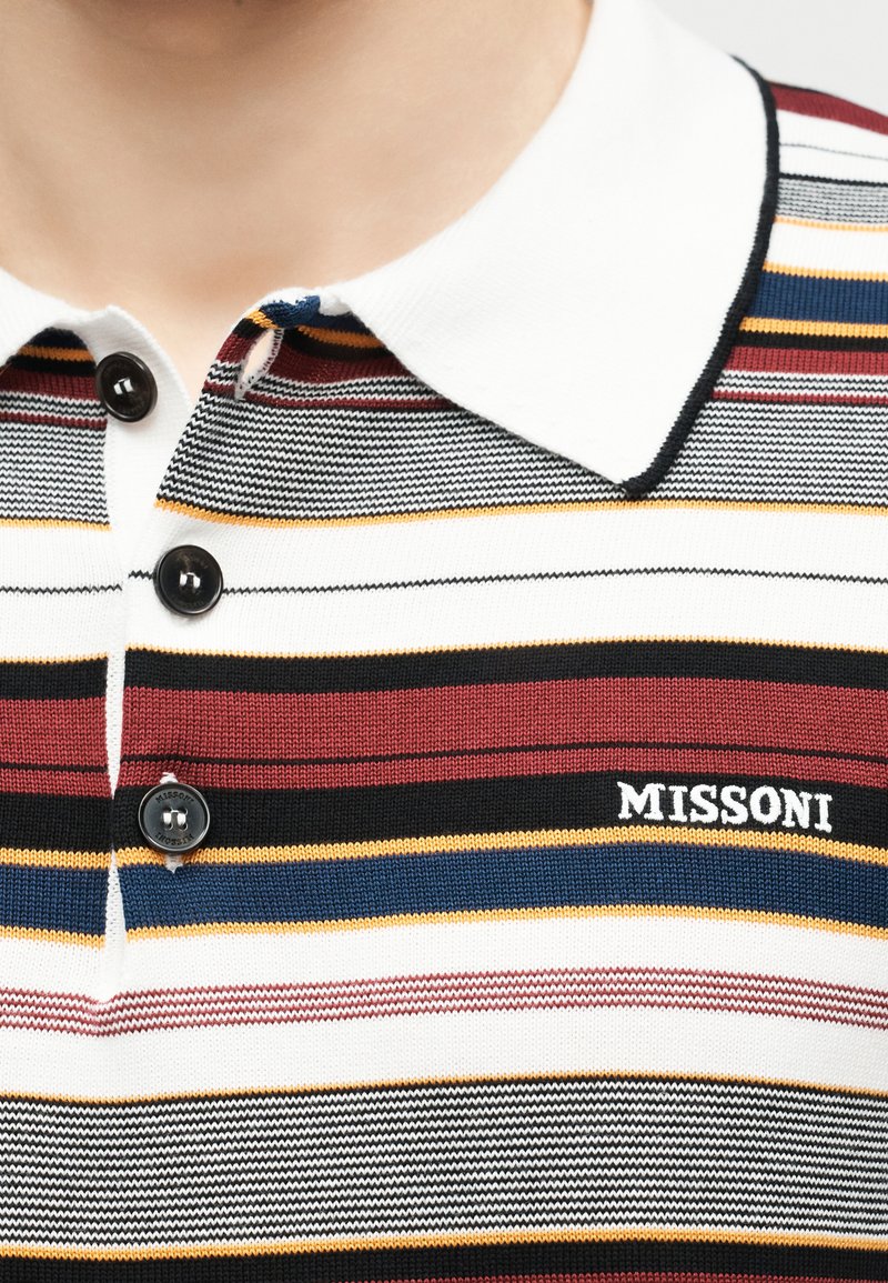 Close-up of a multicolored striped polo shirt with black buttons, white collar, and "MISSONI" logo embroidered on the chest.
