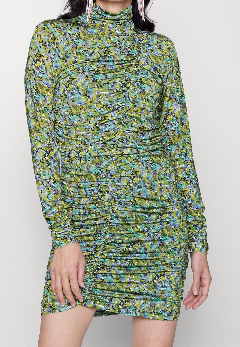 Långärmad, rynkad minikjol i grönt, blått och lila blommönster. Polokrage-design och elastisk tyg med en texturerad finish.