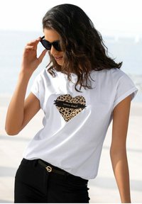 Weißes Baumwoll-T-Shirt mit einem herzförmigen Leopardenmuster und dem Text "Venice Beach" darauf; kurze Ärmel und lockere Passform.
