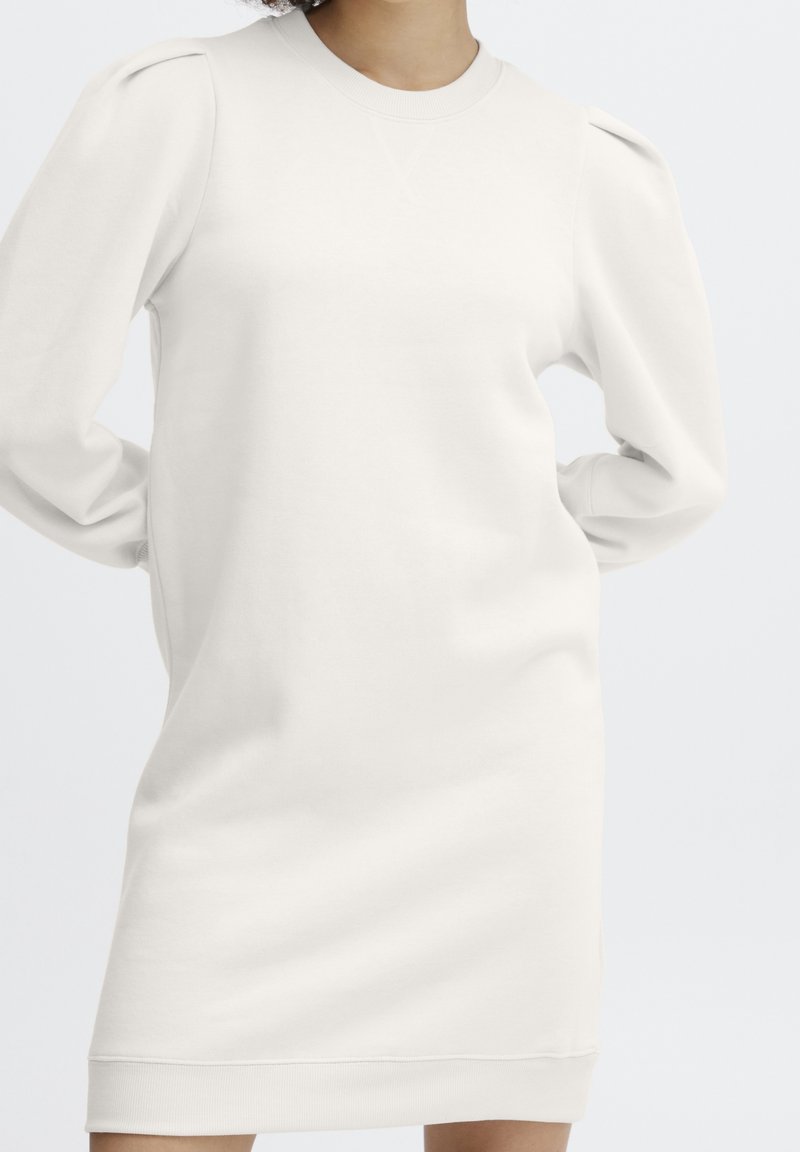 Robe sweat-shirt couleur crème à manches longues, avec épaules bouffantes, col et poignets côtelés, fabriquée en tissu doux en mélange de coton.