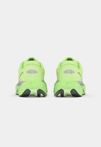 Lime green running shoes with a textured mesh upper, padded collar, and black rubber outsole featuring a zigzag pattern for traction.