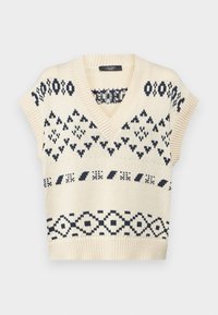 Pull en maille beige à manches courtes et col en V profond, avec des motifs géométriques bleu marine et des bords côtelés texturés.