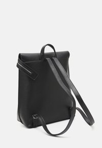 Czarny skórzany plecak o sztywnym kształcie, z uchwytem na górze, dwoma regulowanymi paskami oraz boczną kieszenią na zamek dla dodatkowej funkcjonalności.