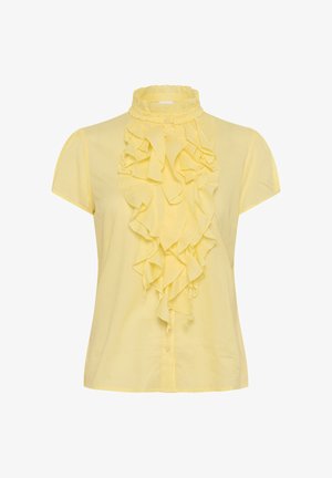 Geltona medvilninė bliuska su aukštu volaniniu apykakle ir priekiniais volanais. Trumpomis rankovėmis ir mygtukų užsegimu priekyje.