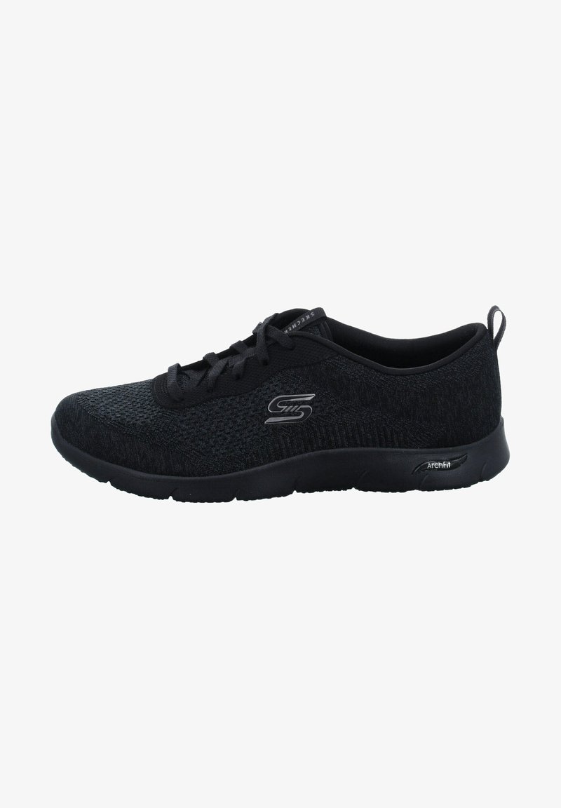 Chaussure de sport noire avec une tige en tricot texturé, un design à lacets, un col rembourré et une semelle amortissante. Présente un logo "S" argenté sur le côté.