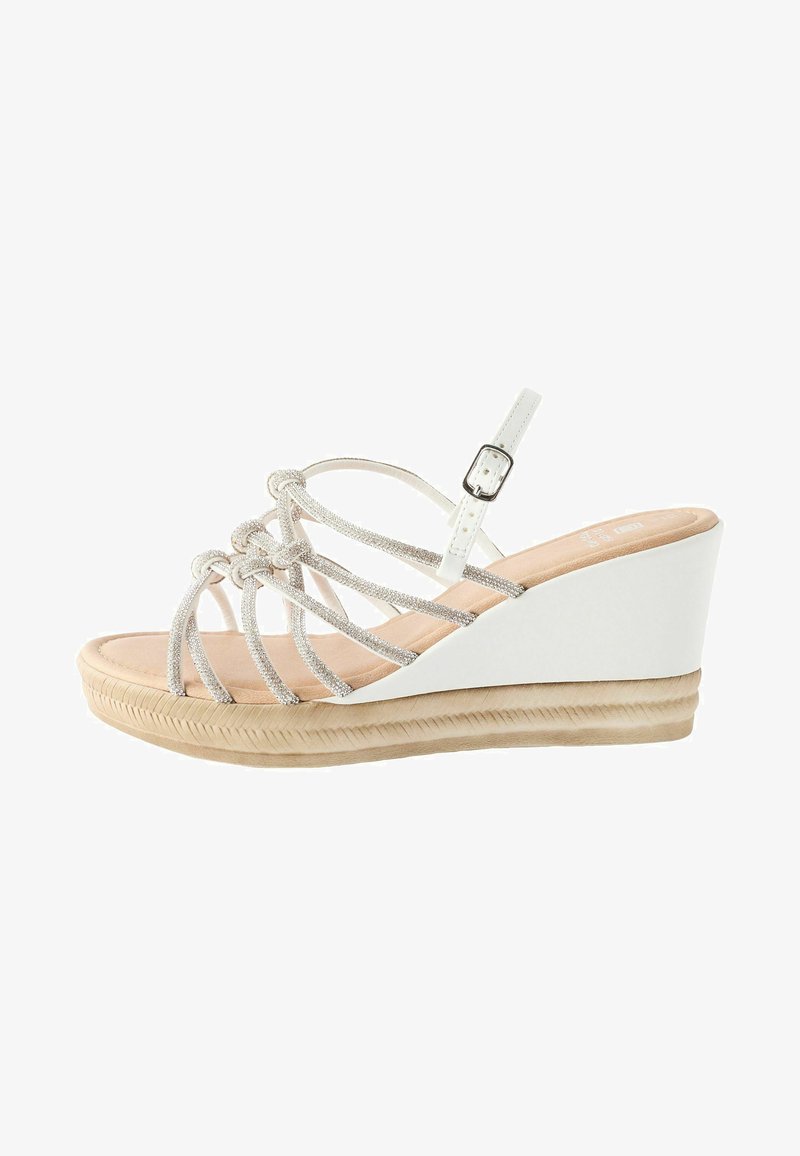 Sandales à talon compensé avec une base blanche, des brides en argent tressées, une boucle ajustable et une semelle texturée pour une meilleure adhérence et stabilité.
