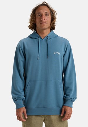 Light blue hoodie made of soft fabric, featuring a front pouch pocket, drawstrings, and a small white logo on the chest.