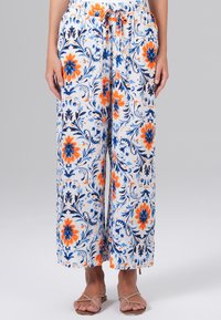 Bloemige wijde broek in het wit, met blauwe en oranje bloesems, een elastische tailleband met een trekkoord, en een lichtgewicht stof.