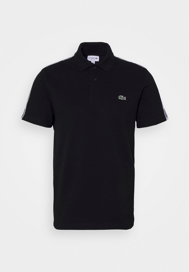 Polo noir à manches courtes avec col, deux boutons, logo crocodile vert sur la poitrine et bandes blanches de marque sur les épaules et les manches.