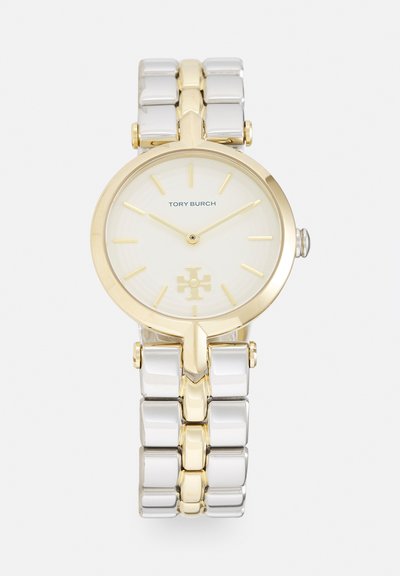 Montre-bracelet Tory Burch or et argent avec cadran blanc, index dorés et logo à 6 heures sur bracelet en métal à maillons.